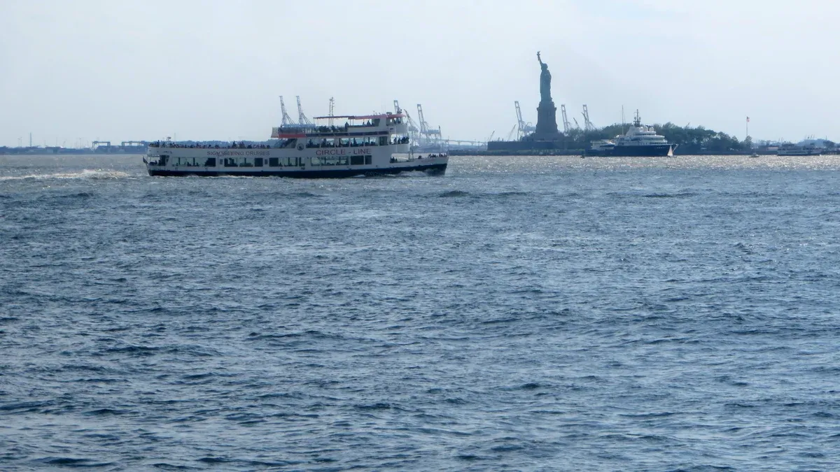 Circle Line sightseeing boat in New York Harbor with the Statue of Liberty behind, part of a New York architecture boat tour