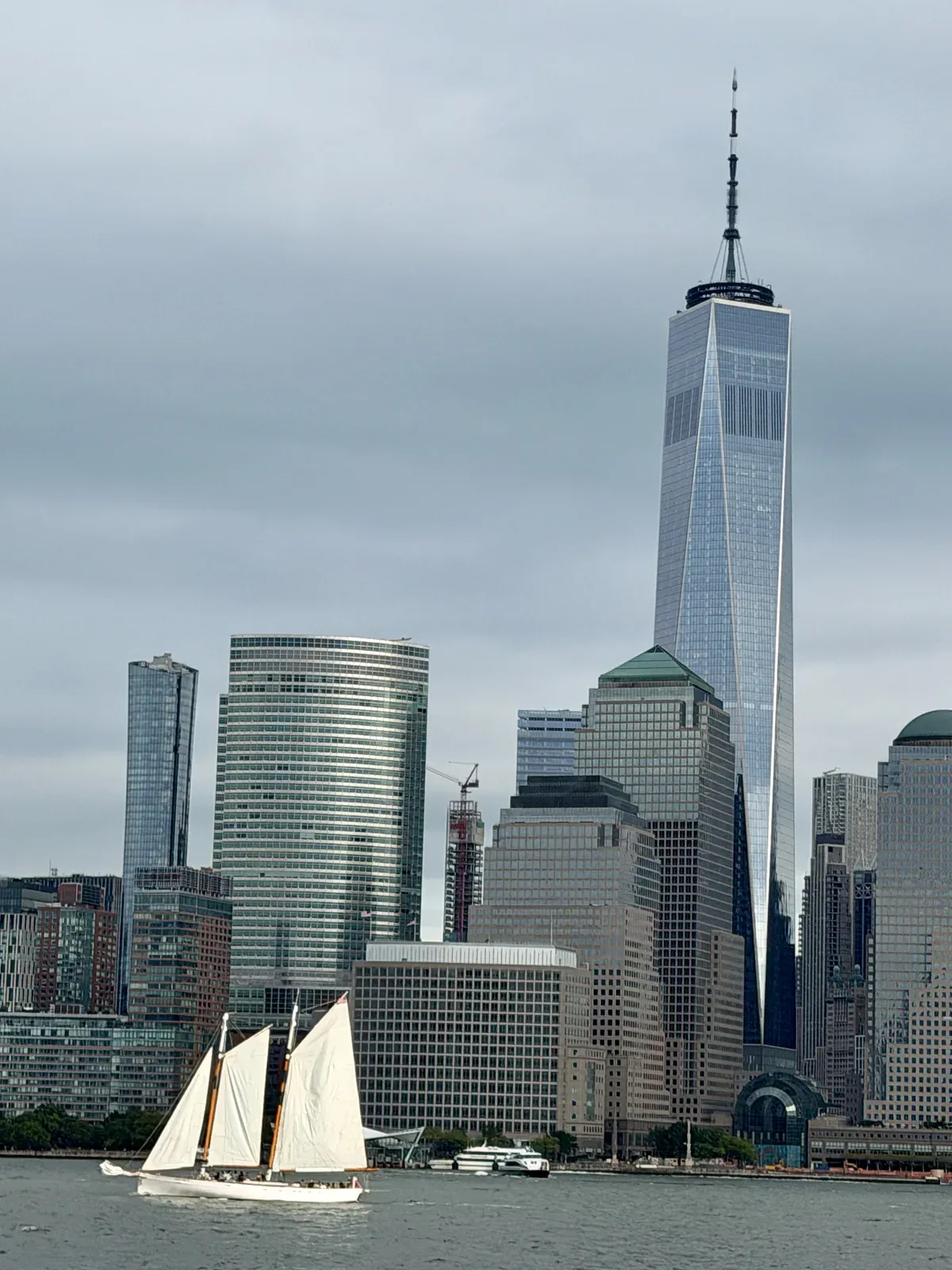 Schooner under sail below One World Trade Center and Lower Manhattan, a sailing option for an architecture boat tour in New York