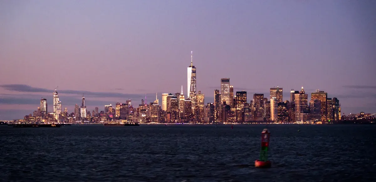 Lower Manhattan skyline at dusk from the harbor, as seen on a New York architecture boat tour