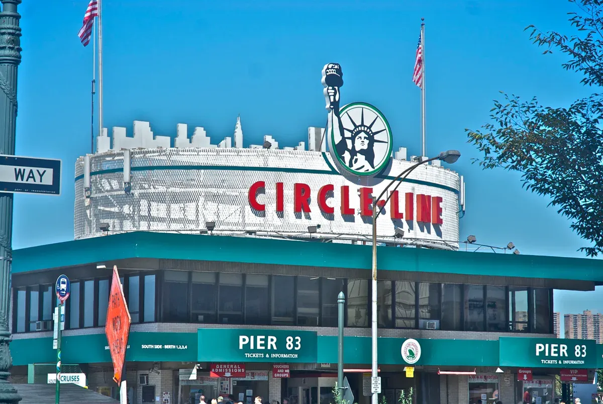 The Circle Line ticket building at Pier 83, with its Statue of Liberty sign, on the Hudson waterfront at West 42nd Street, part of a New York architecture boat tour